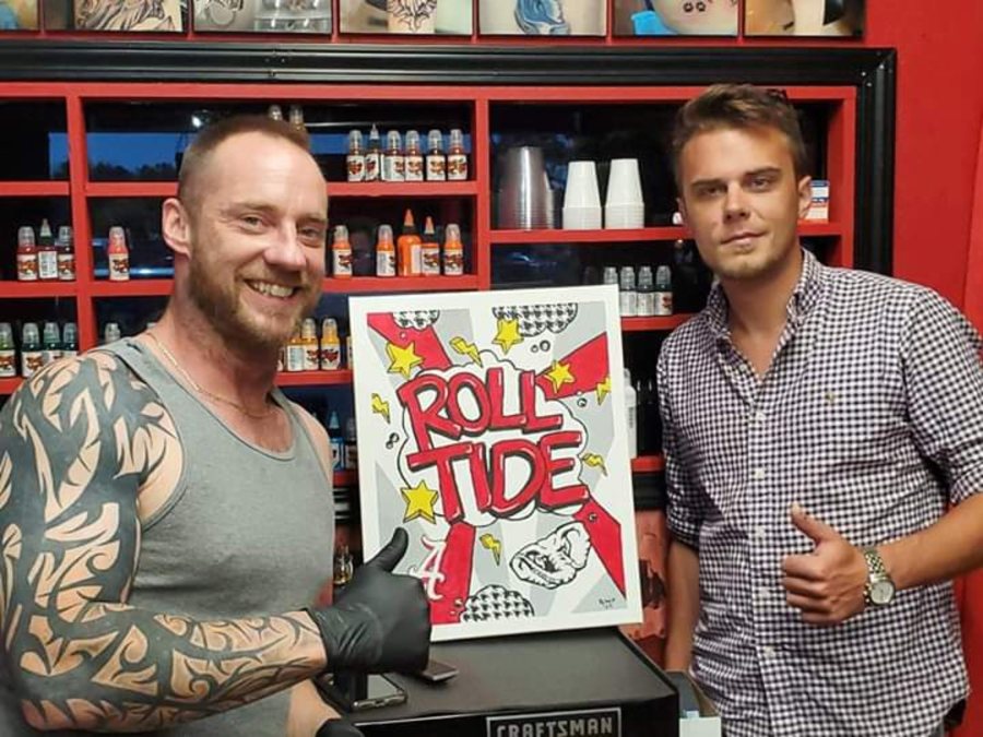 Beau Pendergraft with a collector holding a Roll Tide painting