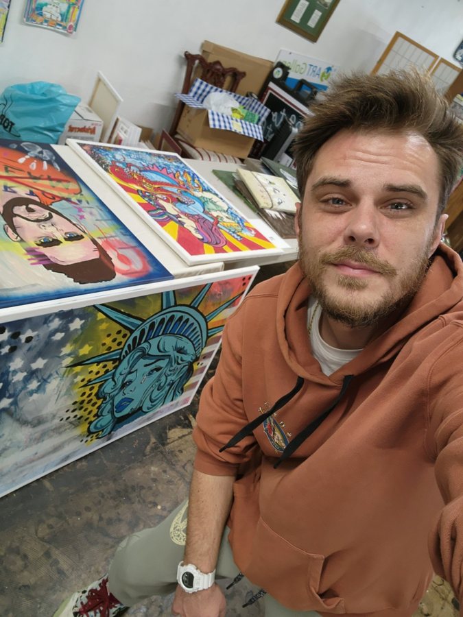 Beau Pendergraft selfie in his studio surrounded by finished paintings